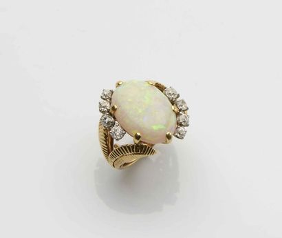 null Bague en or jaune 18 ct (750) ornée d’une opale encadrée de huit diamants taillés...