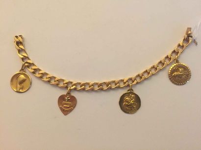 null Bracelet gourmette de femme en or jaune (750) à maillons ornée de quatre médailles....