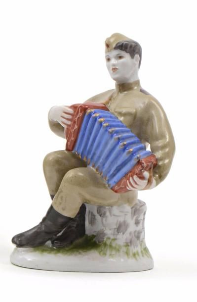 null Groupe en porcelaine polychrome représentant un soldat assis jouant de l’accordéon....