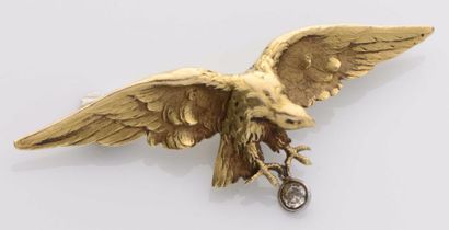 null 78 Broche en or jaune et or gris 18 K (750) ciselée d’un aigle en vol retenant...