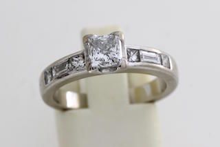 null Bague en or (750 millièmes) ornée d'un diamant de taille princesse épaulé de...