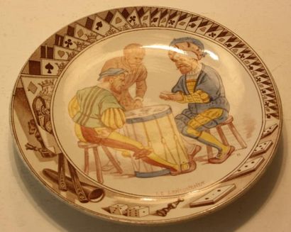 null Une assiette en faïence polychrome. Sarreguemines. Au centre joueurs de «lansquenet»...