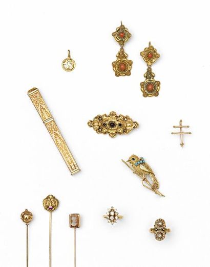 null 89 Broche en or jaune (18K ; 750‰), décorée de volutes et parée de grenats....