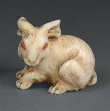 null Netsuke en ivoire représentant un lapin, les yeux en corail.
Signé.
Japon, XIXe...