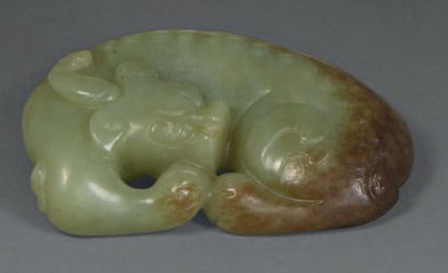 null Statuette en jade blanc et veiné de rouille représentant un qilin couché.
Chine,...