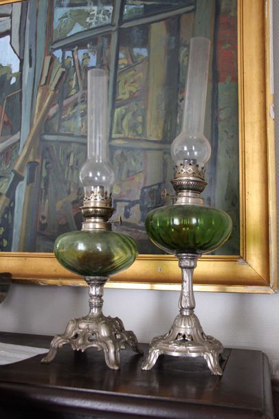 null Deux lampes à pétrole en verre teinté vert et piètement métal ciselé et ajo...