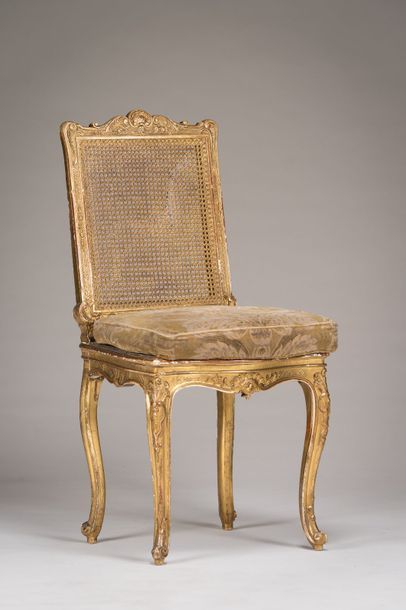 null Chaise cannée à dossier plat en bois sculpté et doré à décor de coquilles, palmes...