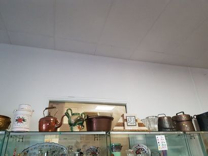 null Au-dessus des vitrines : pièces de forme en cuivre, pendule borne 1930, vases...