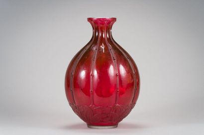 null BACCARAT 
Vase ovoïde sur talon en verre teinté rouge à décor en relief de baguettes...