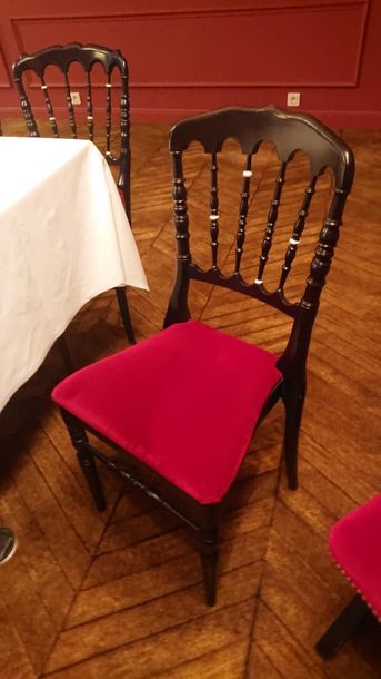 null Suite de 16 chaises à barreaux en bois laqué noir, assise rouge.
Style Napoléon...