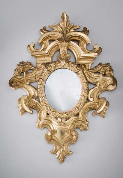 null Petit miroir ovale, l'encadrement en bois sculpté et doré à décor de volutes...