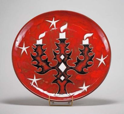 PICART LE DOUX Grand plat circulaire en faïence à fond rouge à décor de candélabres.
Signé...