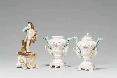 null Paire de vases en porcelaine polychrome à décor de fleurs et putti en relief....