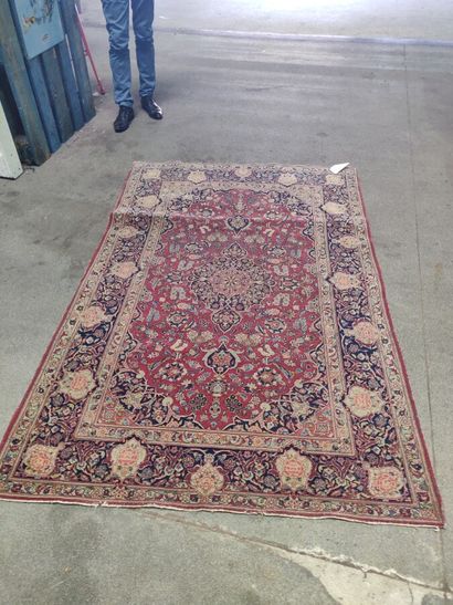 null Oriental carpet with a central blue medallion on a red background, floral decoration....