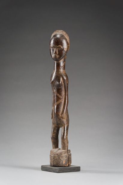 19. Statuette féminine présentée debout sculptée...