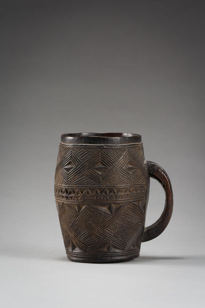 null 44. Palm wine cup engraved with traditional geometric motifs.

geometrical motifs.

Wood,...