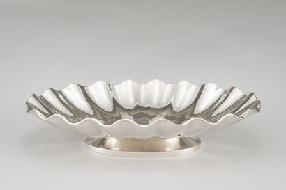 null Oval cup with scalloped edges in hammered silver (800/1000th) resting on a molded...