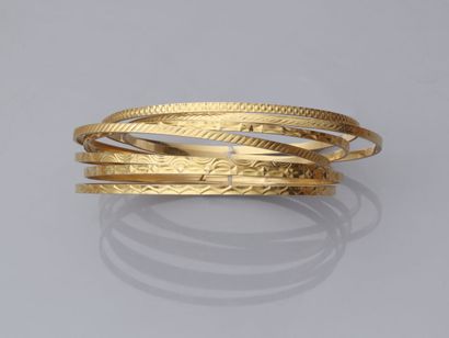 null 30. Ensemble de sept bracelets fins rigides en or jaune

750/1000 à décor géométrique.

Poids...