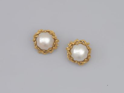 null 48. Pair of 18K (750) gold textured ear clips, each adorned with a button
each...