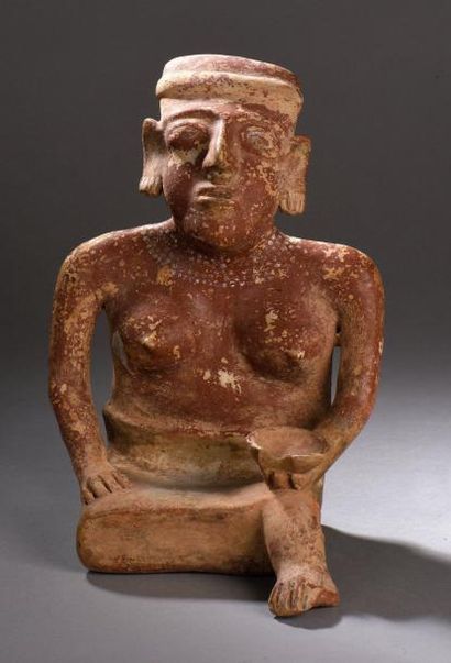 null STATUETTE féminine.
Céramique à engobe rouge partielle. Représente une femme...