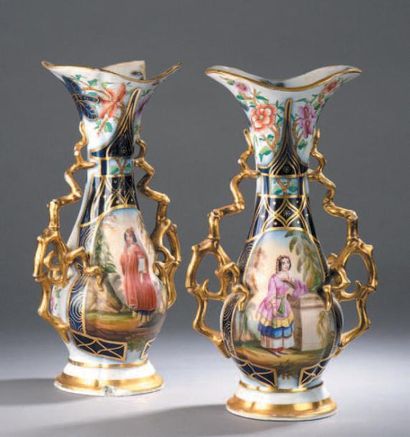 BAYEUX Paire de vases en porcelaine à décor polychrome et or dans des réserves d'élégantes...