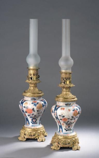 BAYEUX Paire de lampes à pétrole en porcelaine à décor polychrome et or dans le gout...