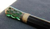 null Canne en bois noirci, pommeau en verre teinté vert inséré dans du métal formant...