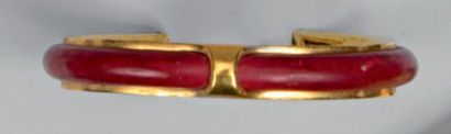 HERMES Bracelet jonc ouvert en métal doré (750°/00) tendu de cuir rouge. Années 70-80....