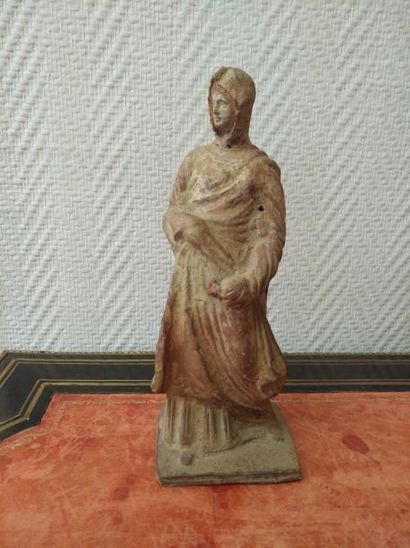 null STATUETTE en terre cuite. Représente une femme vêtue de l'himation.
Style de...