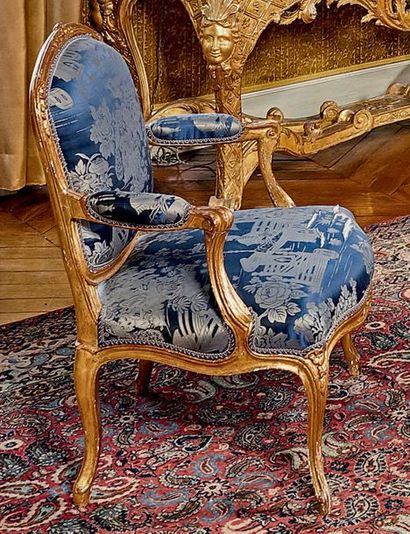 null Paire de fauteuils à dossier plat en bois redoré mouluré et sculpté de fleurs....