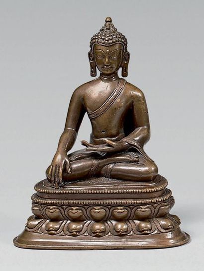 TIBET Statuette de bouddha en laiton à patine brune, assis en padmasana sur un socle...