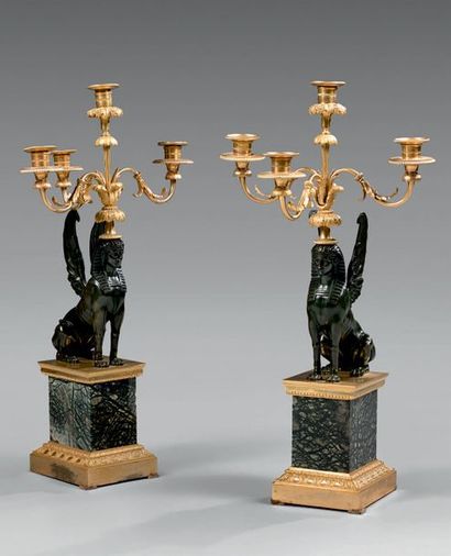 null Paire de candélabres ornés des sphinx ailés en bronze patiné supportant un bouquet...