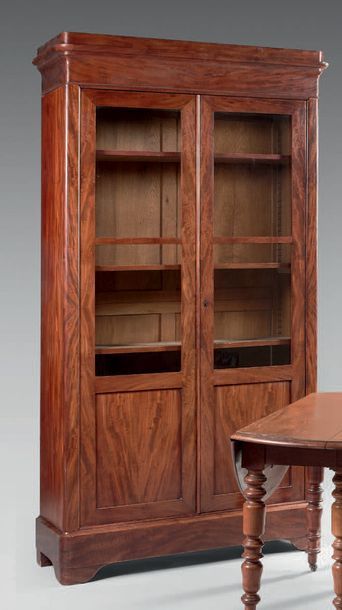 null Mahogany bookcase with flamed mahogany veneer, opening to two partially glazed...