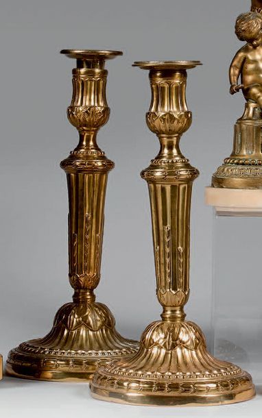 null Pair of large torches in gilt bronze with a fluted shaft rudented with asparagus...