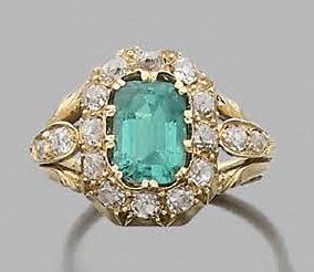 null Ring adorned with a rectangular emerald with cut sides in a circle of old cut...