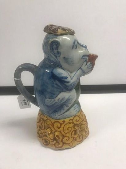 DELFT Covered jug in the shape of a monkey sitting on a base with a yellow base decorated...