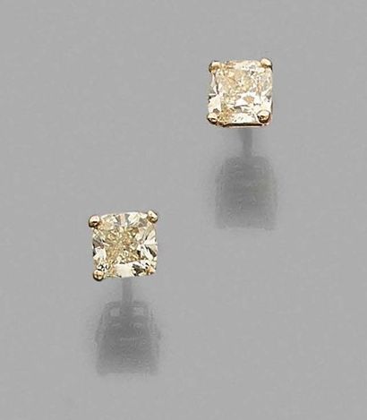null Pair of 750 thousandths yellow gold earrings each adorned with a princess cut...