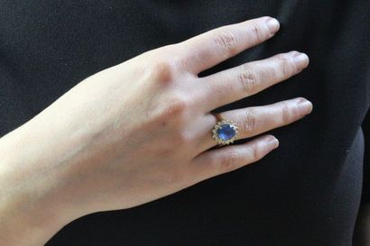 null Ring set with an oval-shaped sapphire in a setting of round brilliant-cut diamonds,...