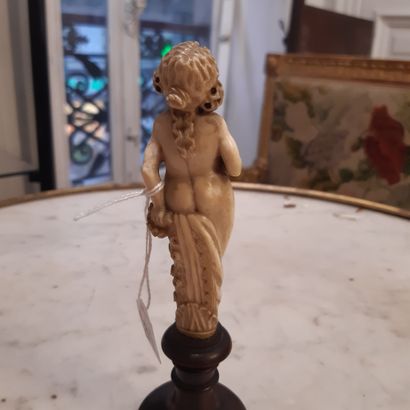 null Carved ivory statuette of a naked young woman holding a bouquet of flowers.
Turned...