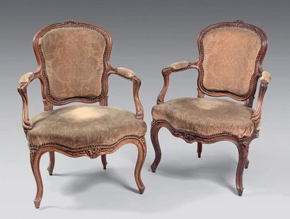 null Pair of convertible walnut armchairs moulded and carved with two flowers. Cuffed...