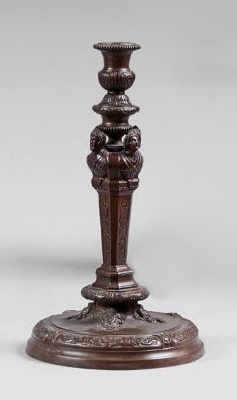 null Torch in patinated bronze, decorated with four masks. Panelled shaft, round...