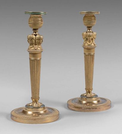 null Pair of gilt bronze torches, decorated with three Egyptian heads. Fluted shaft...