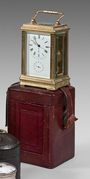 null Small travel clock in a brass cage frame engraved with foliage. Enamel dial...
