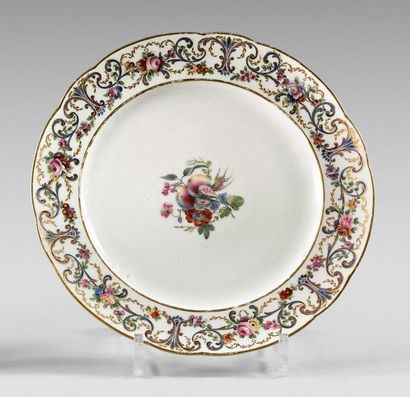 SÈVRES Plate with contoured rim with polychrome and gold decoration in the center...