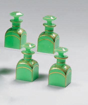 null A suite of four small opaline perfume bottles with gold scrolls.
Mid 19th century.
Height:...