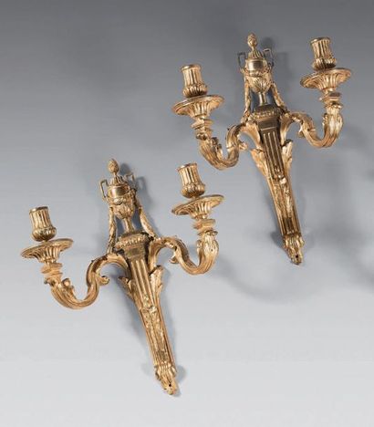 null Pair of gilt bronze wall lights with two leafy lights. Fluted shafts decorated...
