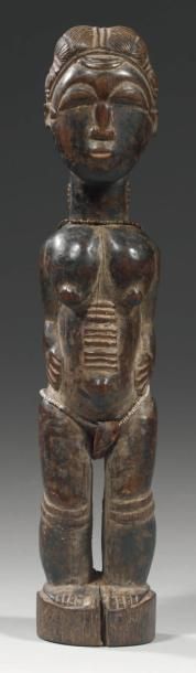 null STATUETTE FÉMININE. Bois lourd, belle patine brune luisante. Scarifications...