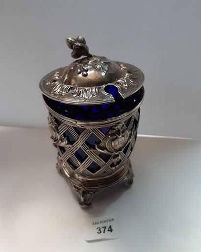 null A silver openwork mustard pot with basketry decoration, standing on four feet,...