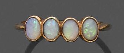 null River ring in yellow gold 750 thousandths adorned with four small cabochon opals.
Finger...