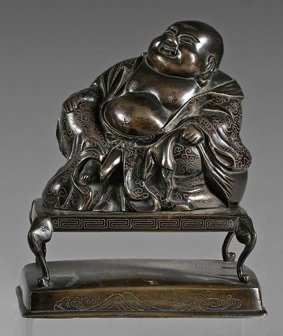 CHINE - XIXe siècle 
Boudai en bronze à patine brune, assis sur une table rectangulaire...